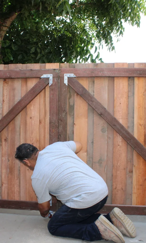 OC Bros handyman repairing wooden gate hinge
