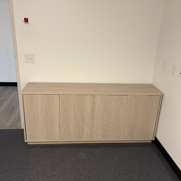 Anaheim office furniture assembly service completing credenza installation against wall in a commercial office.