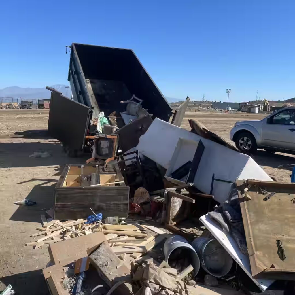 Dump trailer unloading junk and furniture at a disposal site in Orange County during a cleanout job. Dumpster vs Junk Removal Example Image
